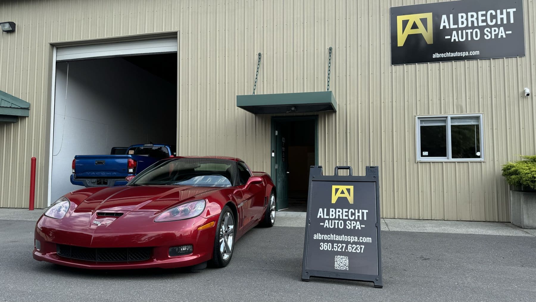 Red Chevrolet Corvette ceramic coated at Albrecht Auto Spa in Ferndale, WA, shop sign in frame