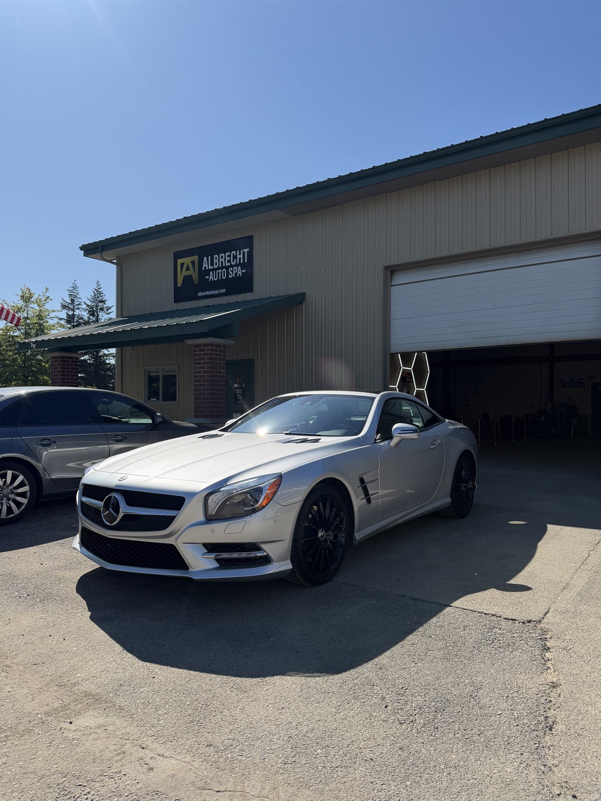 Silver Mercedes-Benz SL roadster in the Albrecht Auto Spa driveway